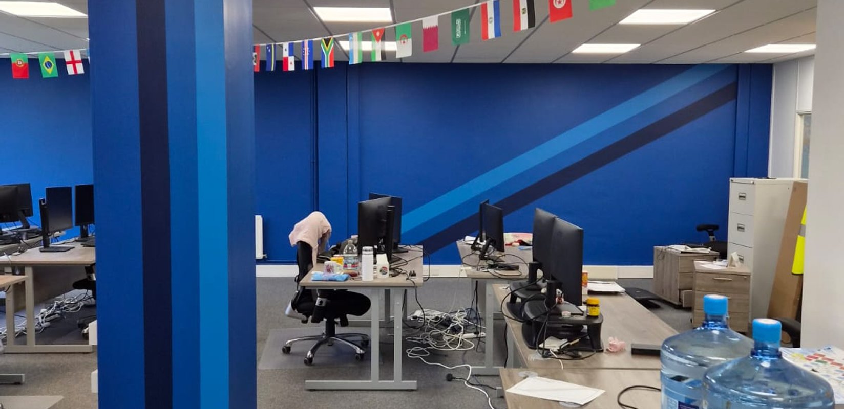 Finished Bertling office with blue branded feature walls, striped columns and diagonal detailing