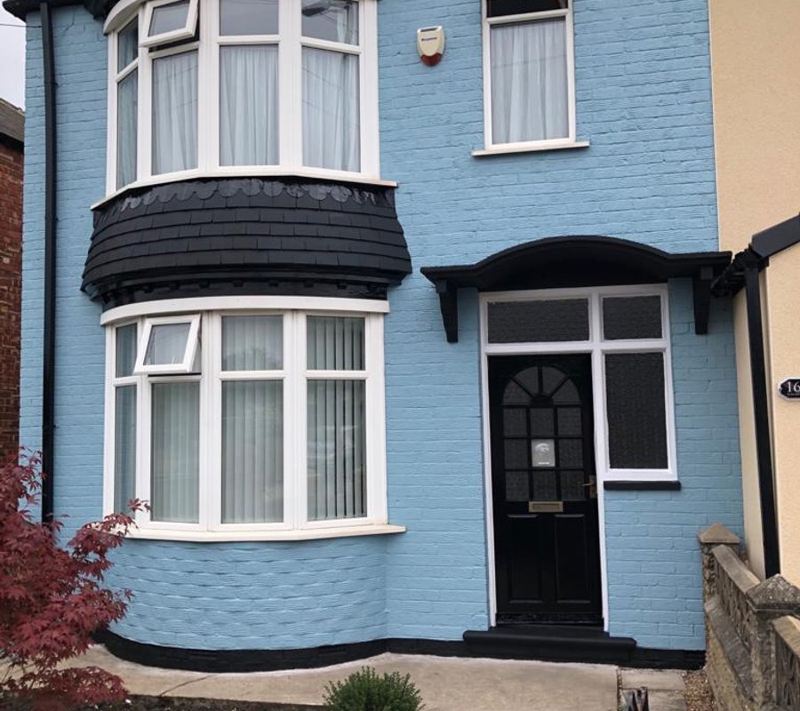Blue painted brick house with contrasting white trim