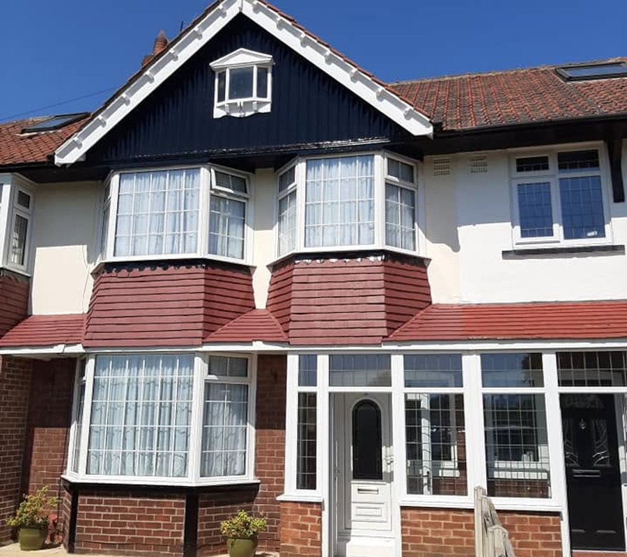 House exterior with a navy gable and painted bay details