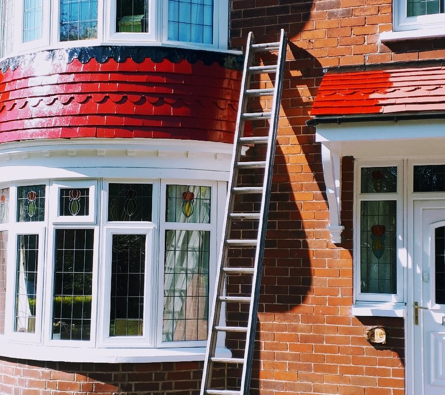 Exterior bay woodwork being painted red