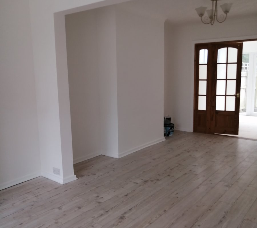 Freshly painted open-plan room with white walls and wood flooring