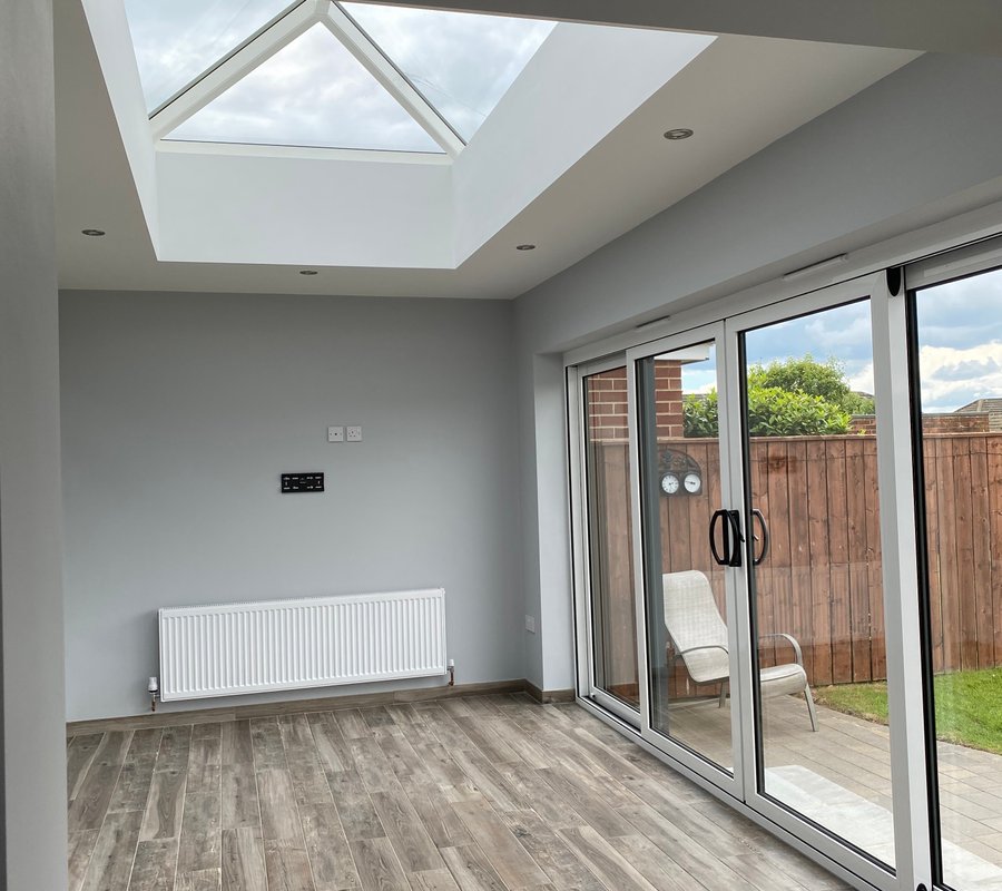 Painted grey extension with a roof lantern and bifold doors