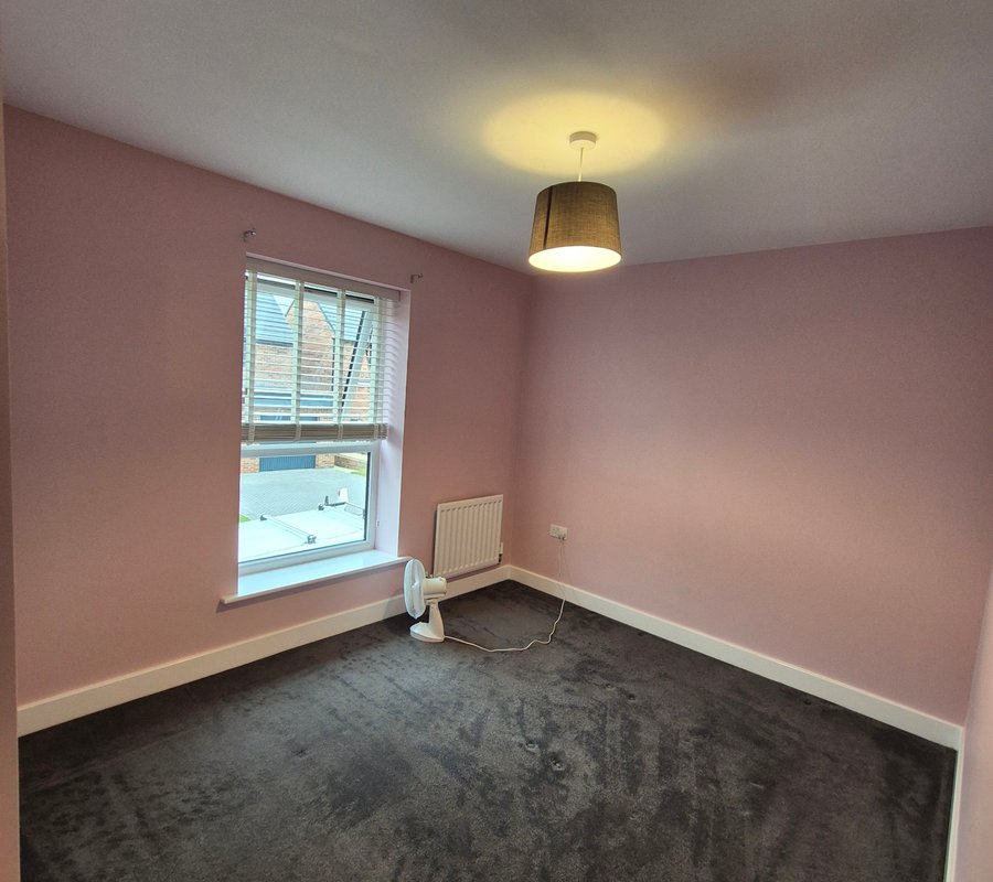 Freshly painted pink bedroom with crisp white woodwork